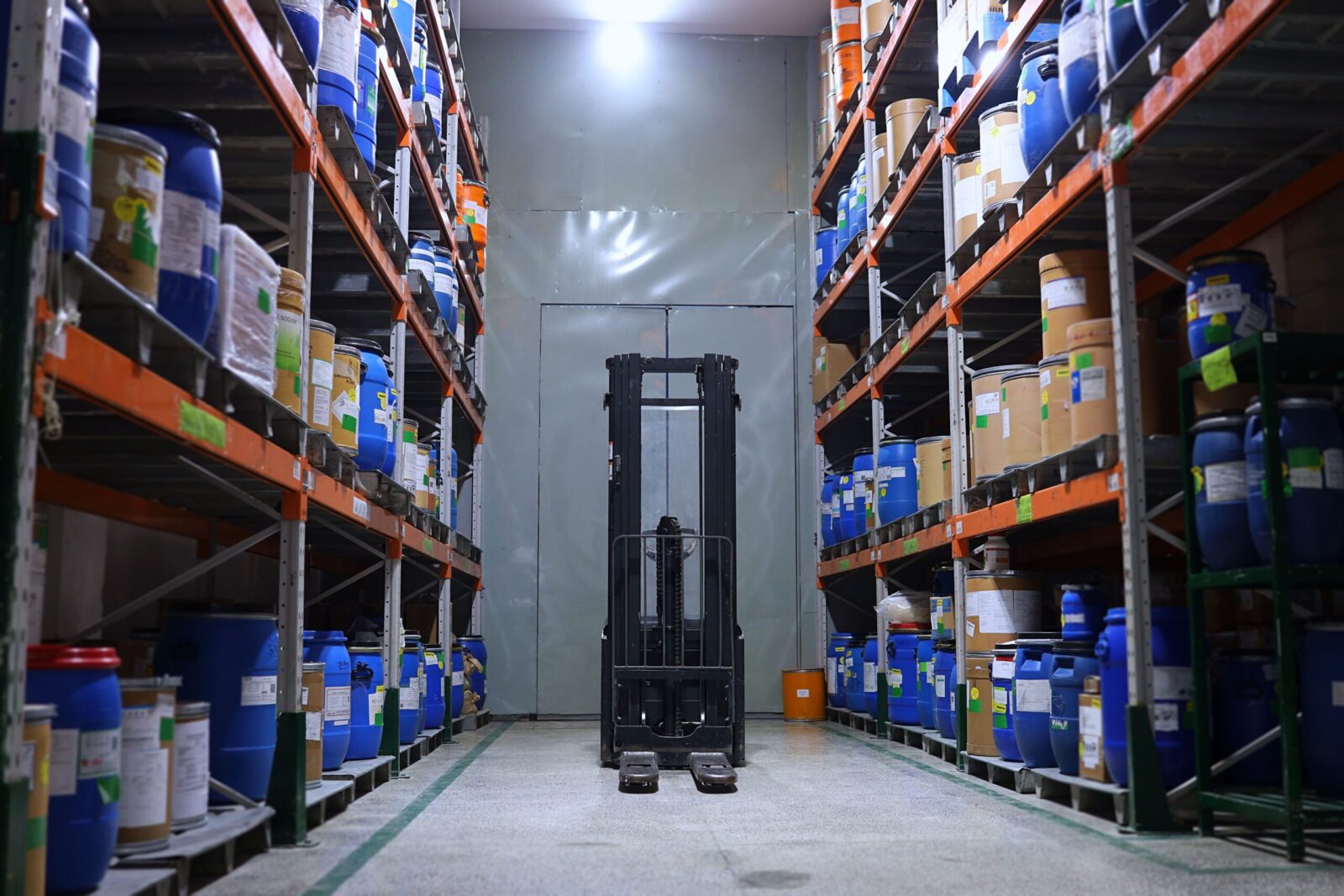 A well-organized pharmaceutical warehouse with shelves and a forklift in Islamabad, Pakistan.